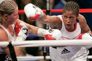 Two female boxers in the ring, one landing a punch