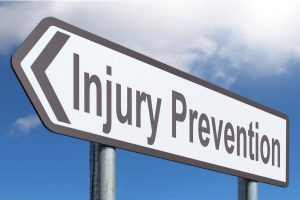 Road sign with 'Injury Prevention' written in bold letters against a clear blue sky.