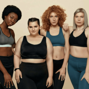 four diverse women in sportswear standing confidently against a beige background