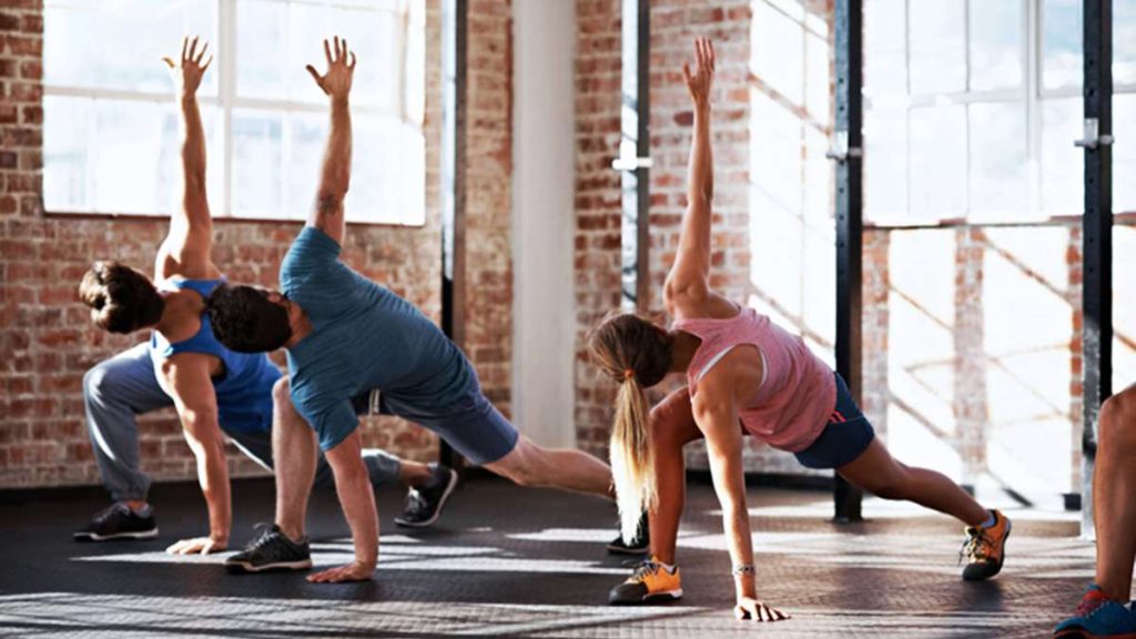 a group of people practicing yoga poses in a studio with brick walls