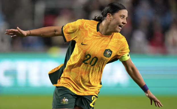 female soccer player in australian national team jersey celebrating on the field