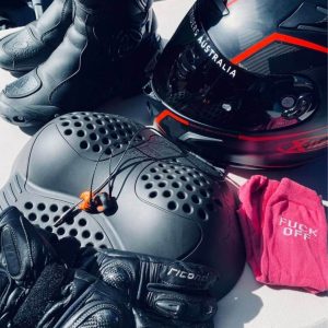 motorcycle gear arranged neatly including boots helmet gloves and protective padding