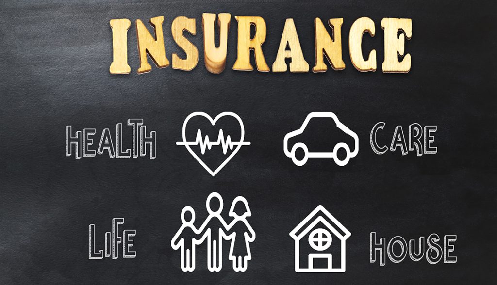 Conceptual image depicting various types of insurance using wooden and chalk icons on a blackboard.